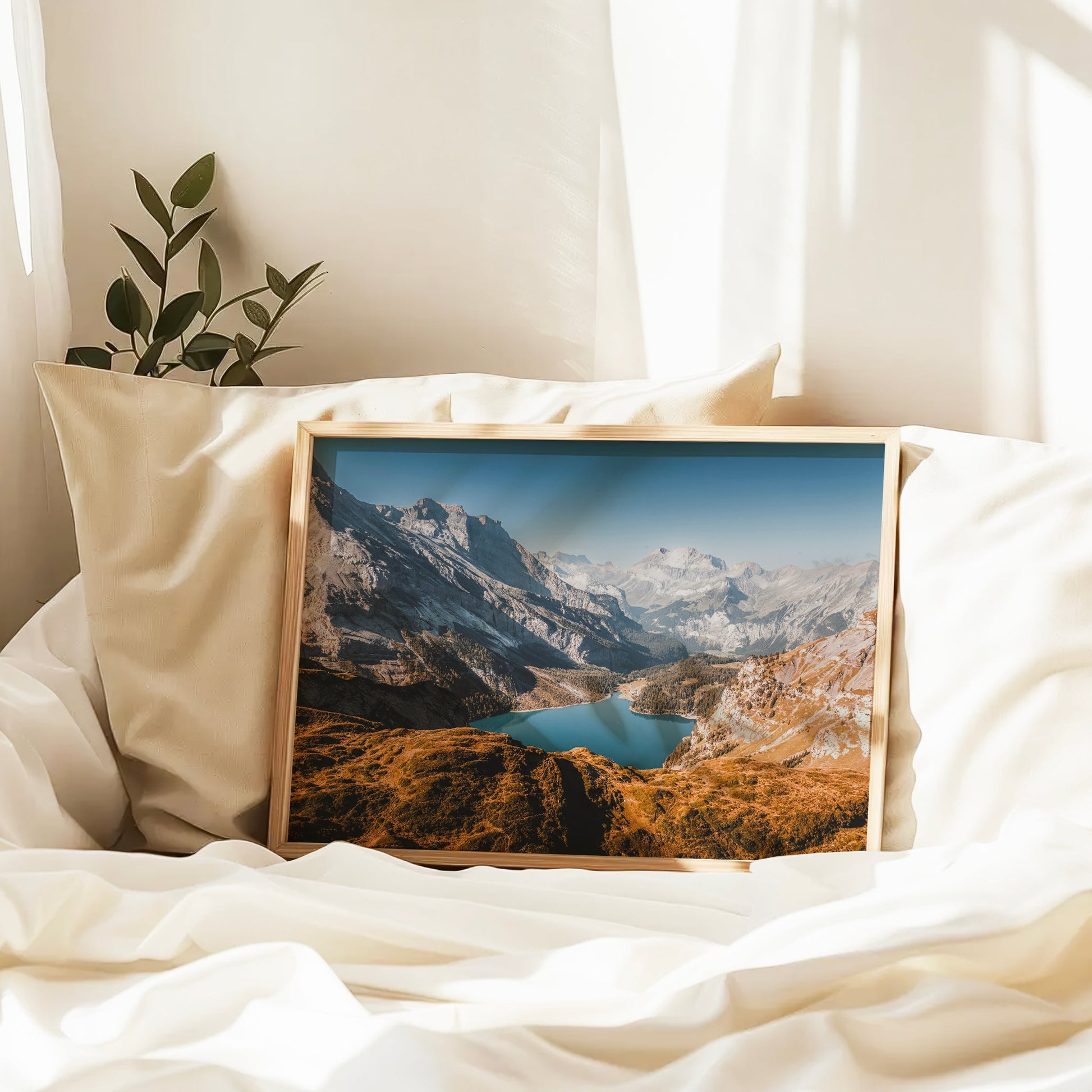 Framed landscape print of Lake Oeschinen on white bedding
