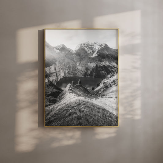 Black-and-white view of Oeschinensee in Switzerland, surrounded by rugged alpine peaks and captured in soft evening light for a serene aesthetic.