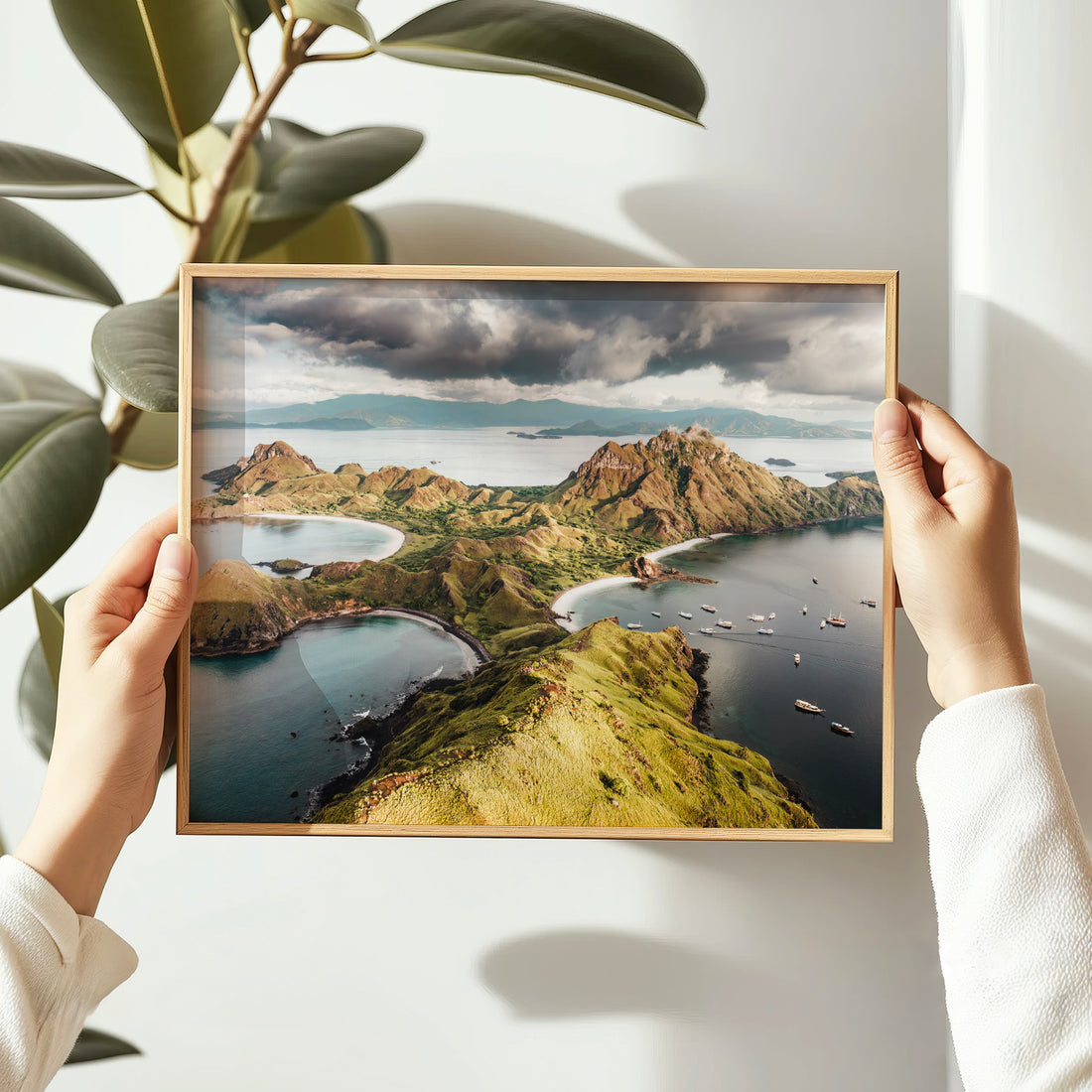 Person holding a natural wood framed print of Padar Island Komodo National Park Flores Indonesia aerial drone photo