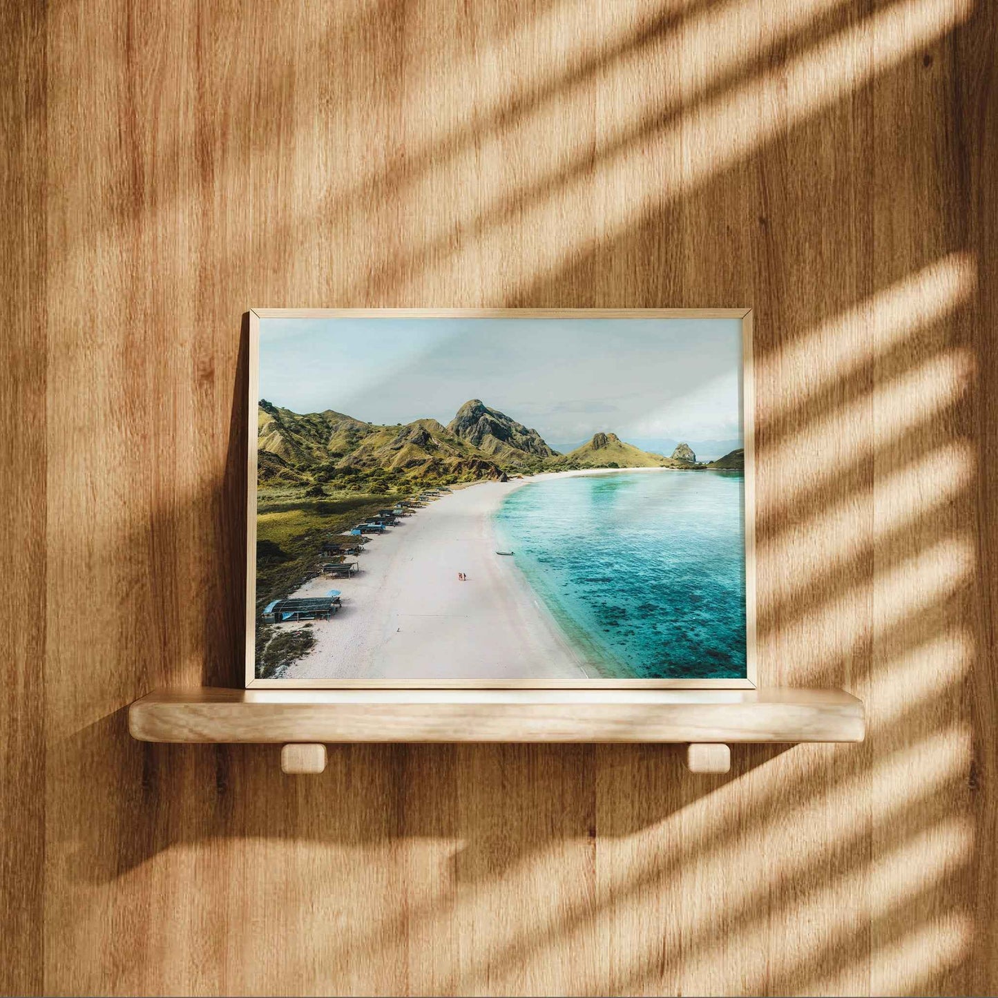 Pink Beach Padar Island Komodo National Park framed photography print displayed on natural wood shelf against wooden wall