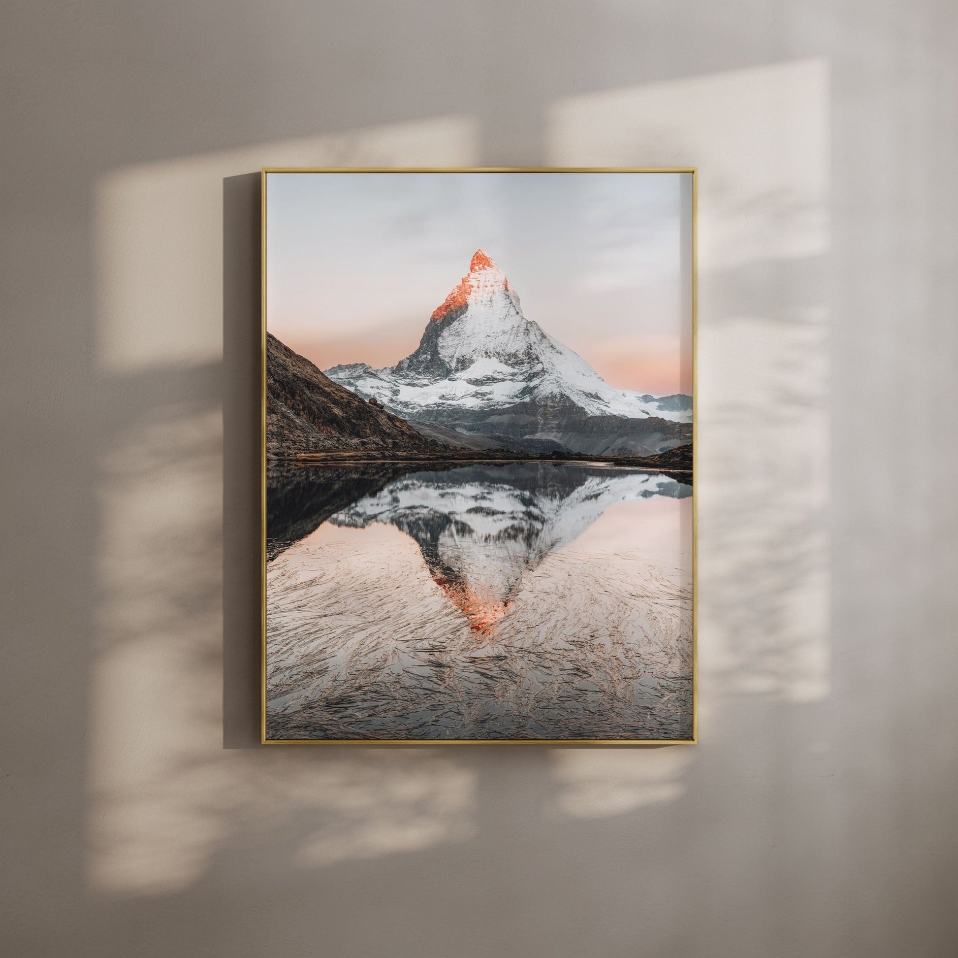 Morning view of Riffelsee with the Matterhorn reflected, framed in gold against a beige wall.