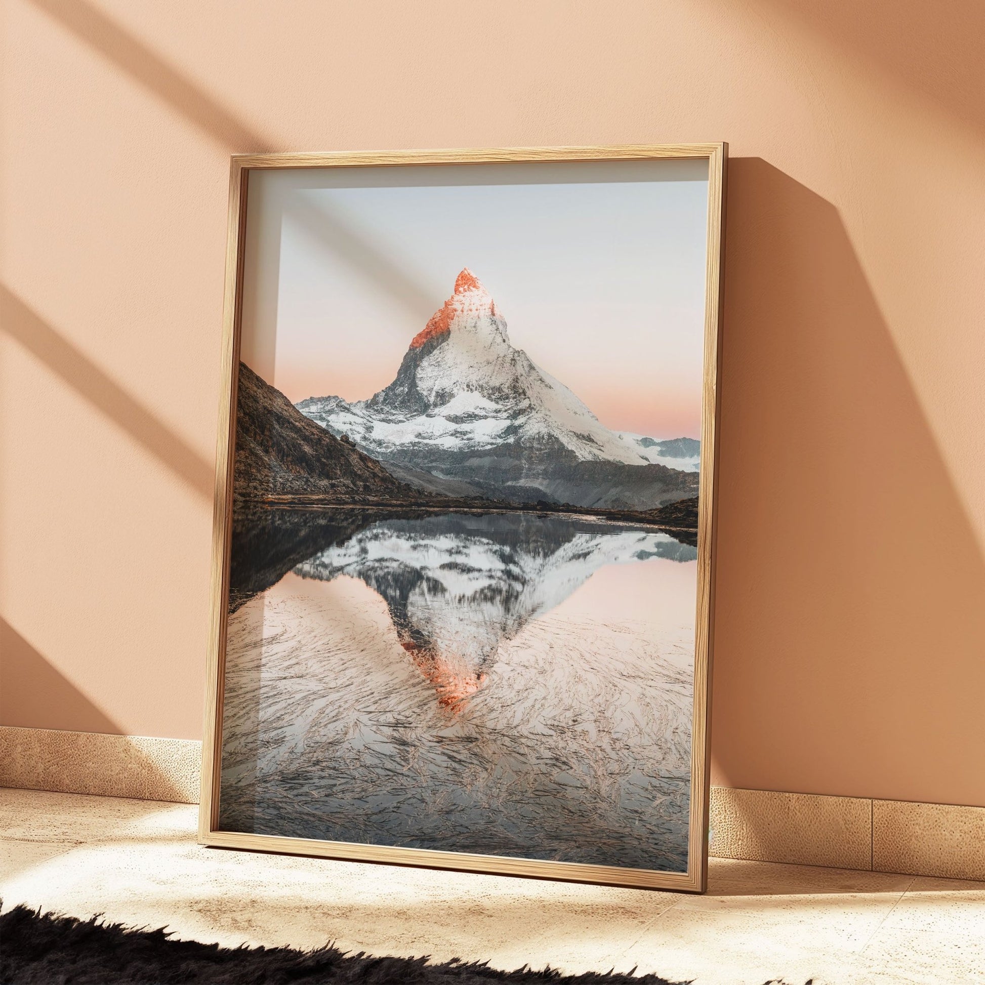 Rustic oak-framed photo of Riffelsee and the Matterhorn’s sunrise reflection, against a peach wall