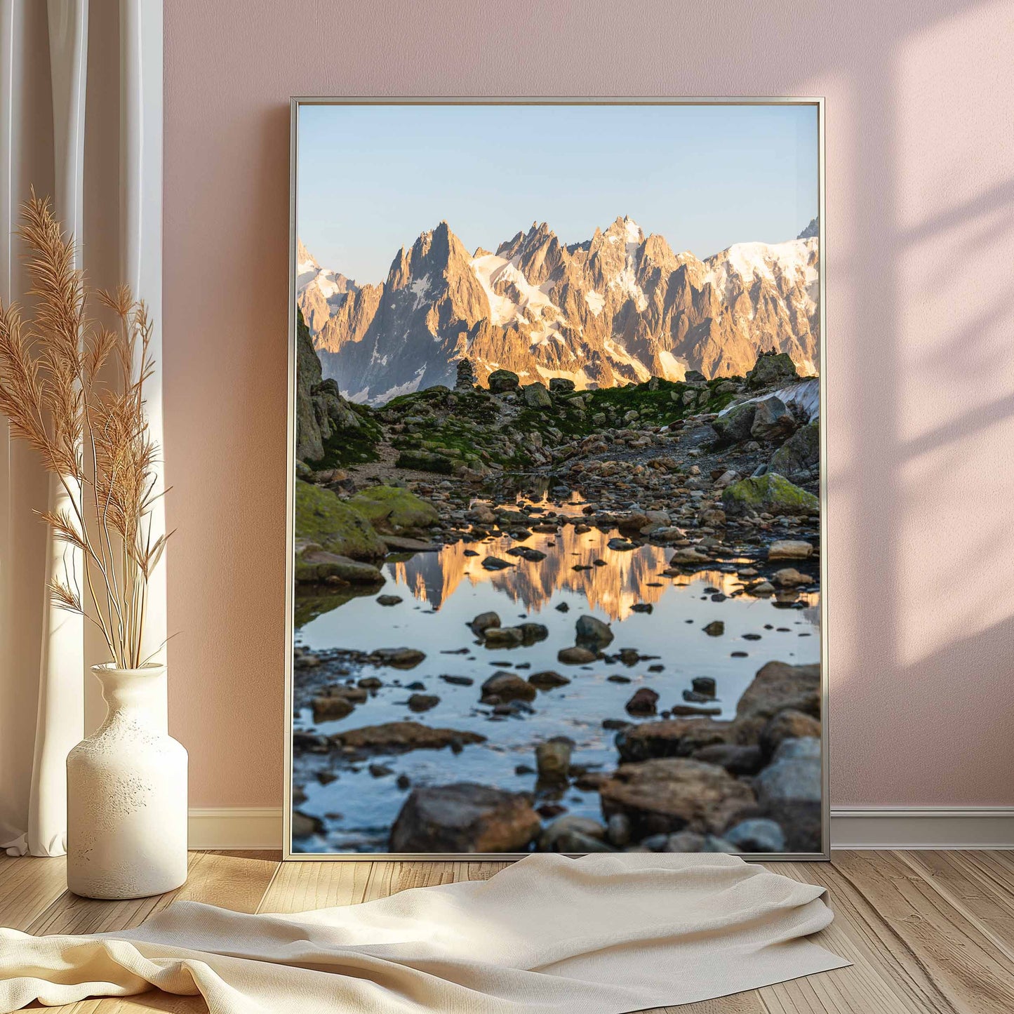 Alpine trail with Aiguille de Chamonix reflected in a puddle, surrounded by rugged terrain.