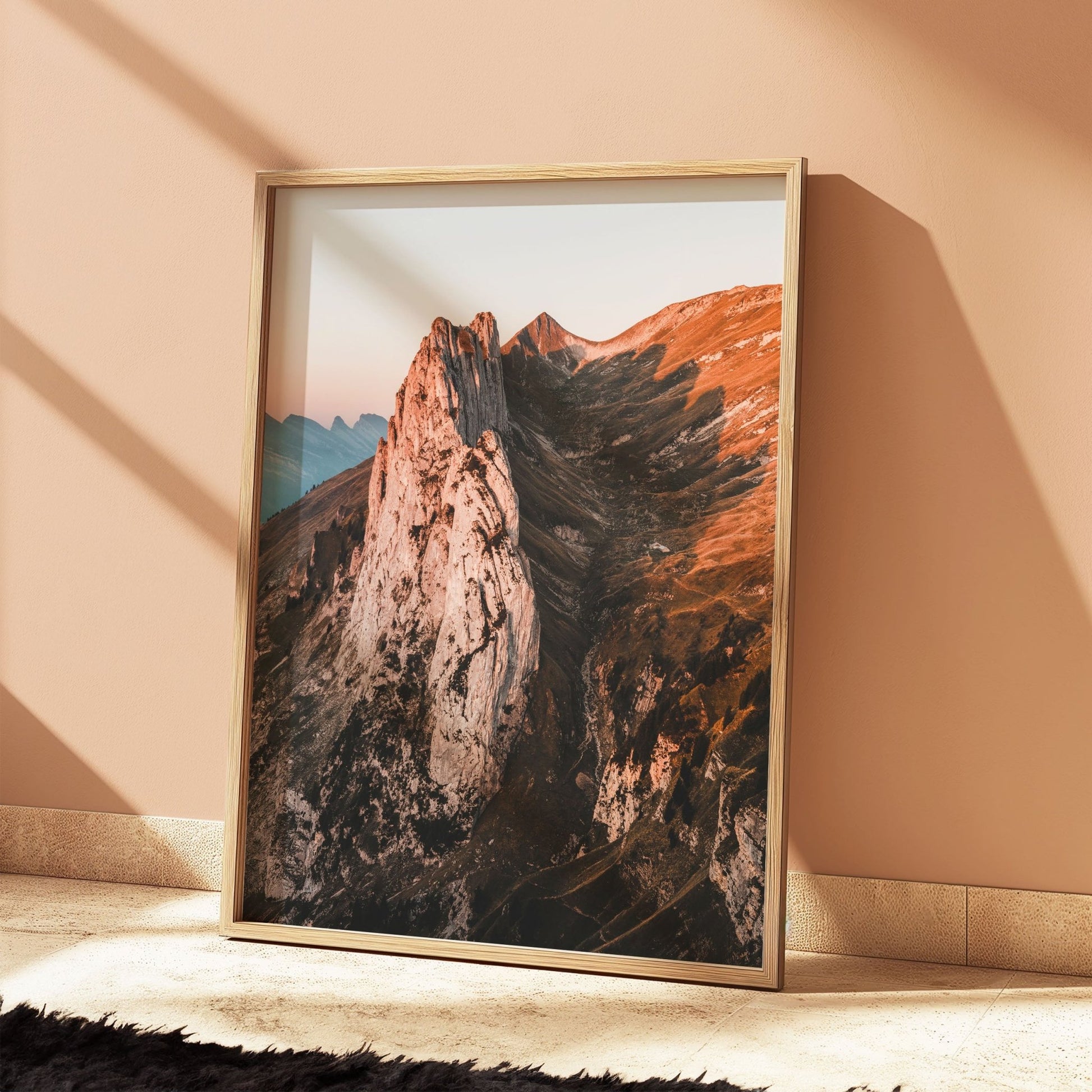 Oak-framed sunrise photo of Saxer Lucke against a peach wall, showcasing earthy warmth.