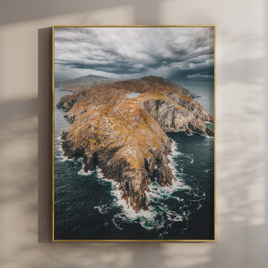 Aerial view of Sheep’s Head Peninsula with dramatic clouds and golden cliffs.