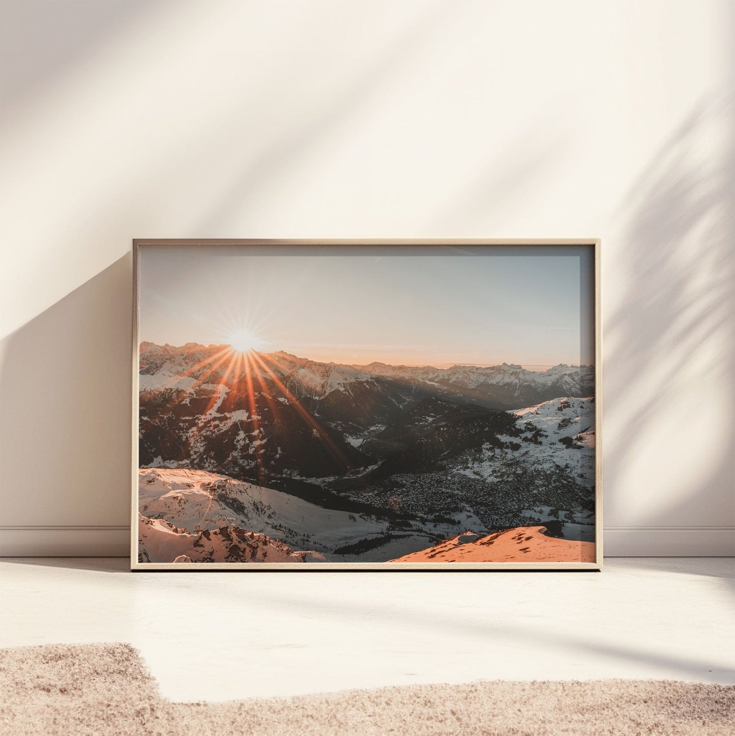 Golden sun rays shining over the Verbier mountain range, blanketed in snow.