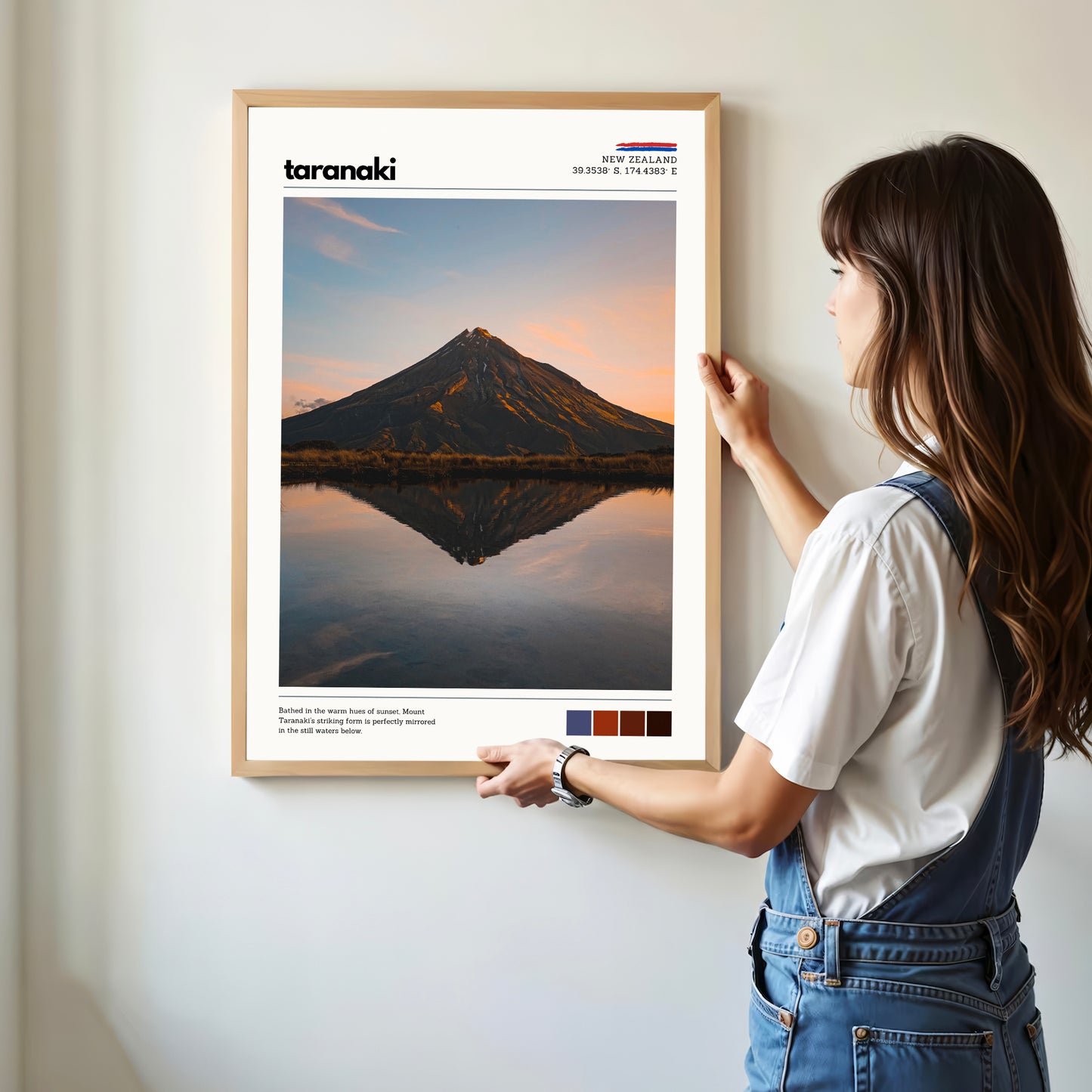 Person hanging a Mount Taranaki wall art print in a bright modern home interior