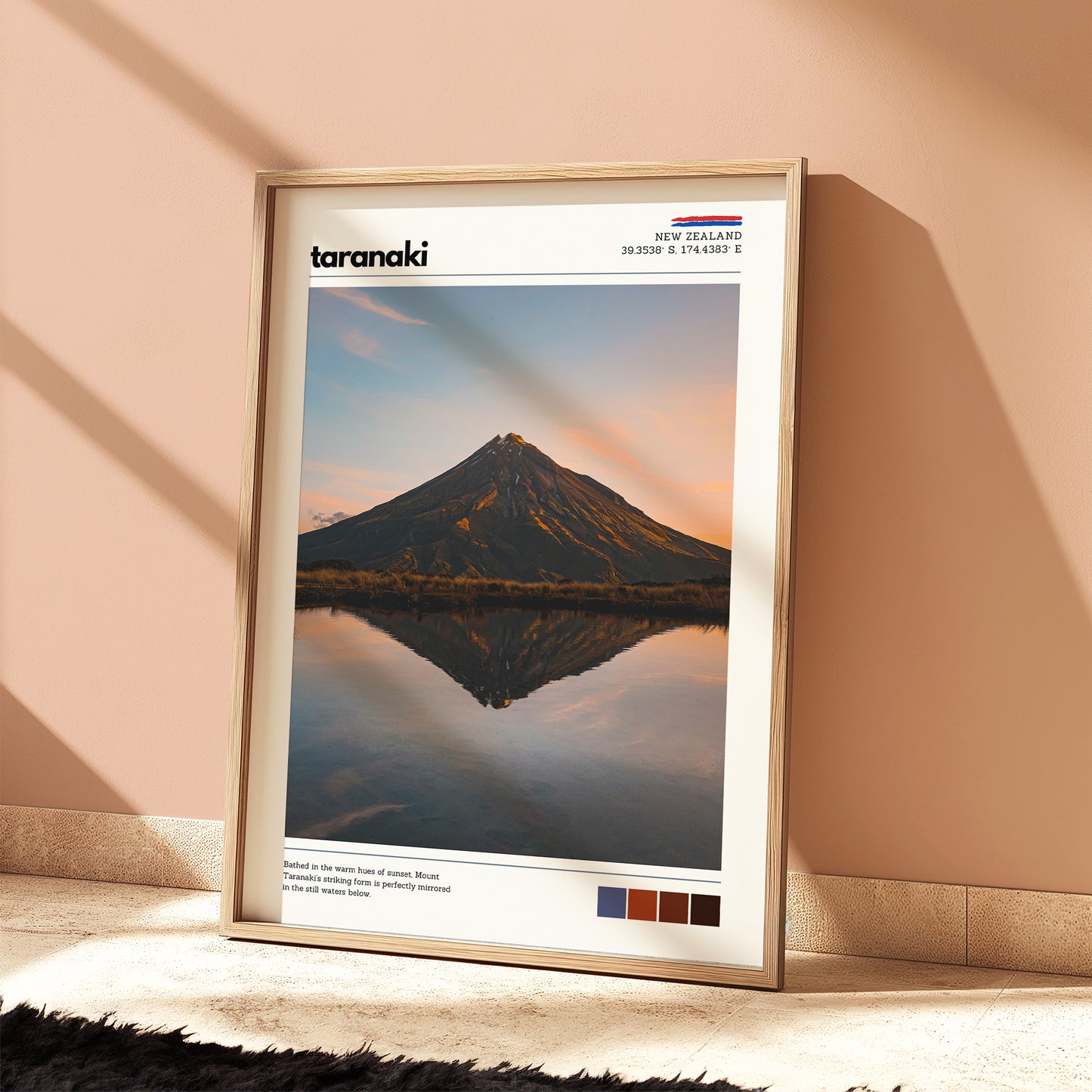 Mount Taranaki fine art print in a wooden frame styled on the floor beside indoor plants