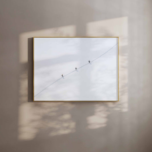 Three mountaineers crossing the Vallee Blanche in a snow-filled landscape with visible footprints.