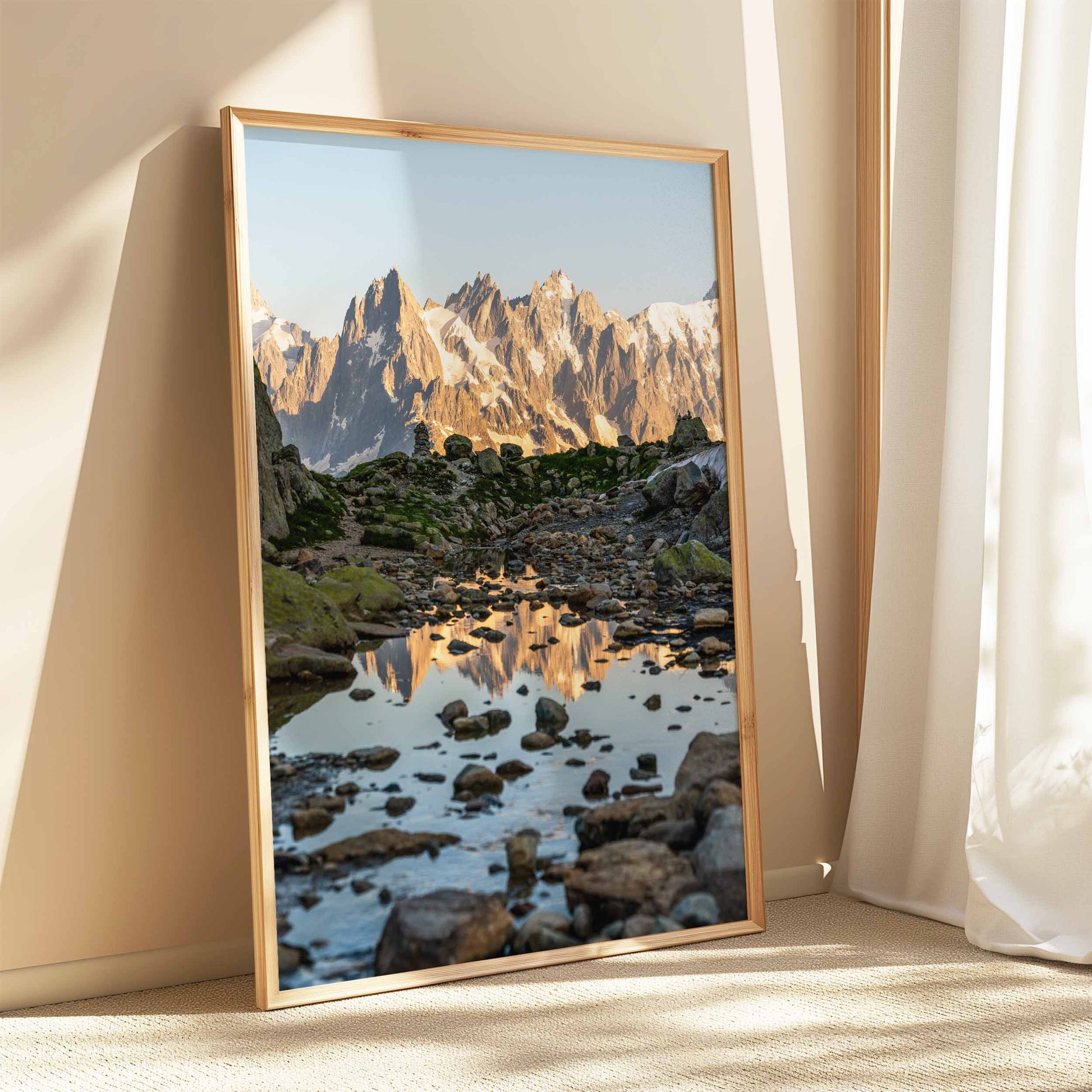 Small alpine puddle reflecting Aiguille de Chamonix with a serene morning sky.